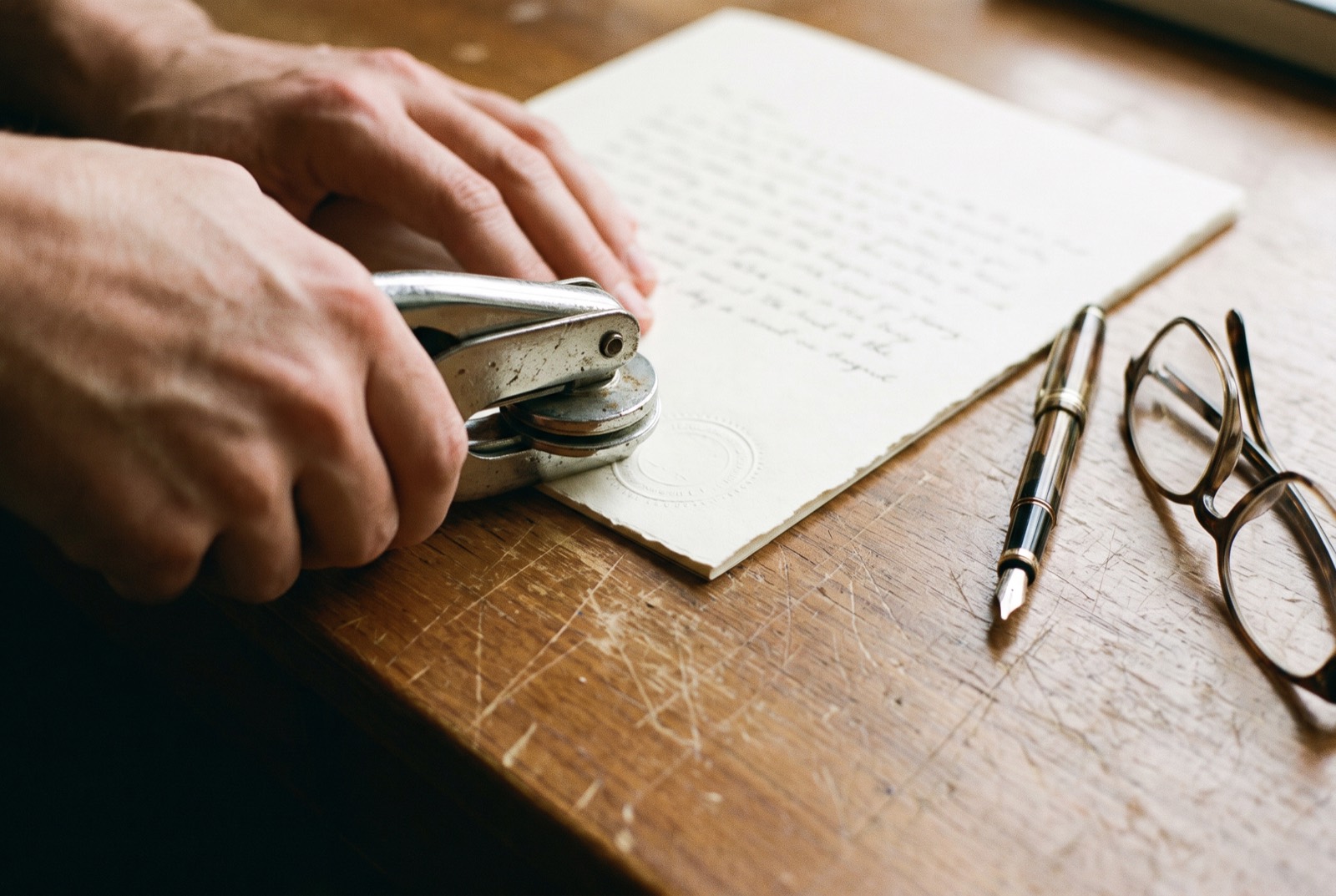 An engineer pressing an embossing seal onto the last page of a report